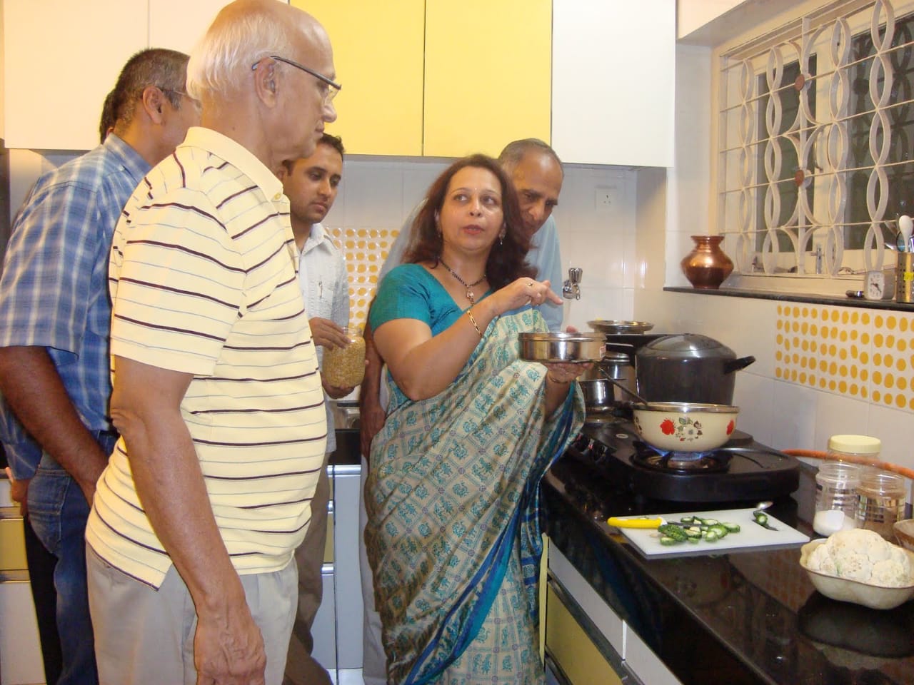 A group of men learning to cook. 