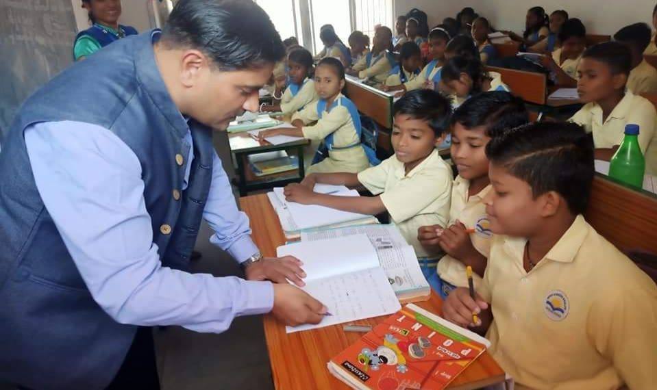 Vijay Kulange interacting with students in a village school as a district collector.