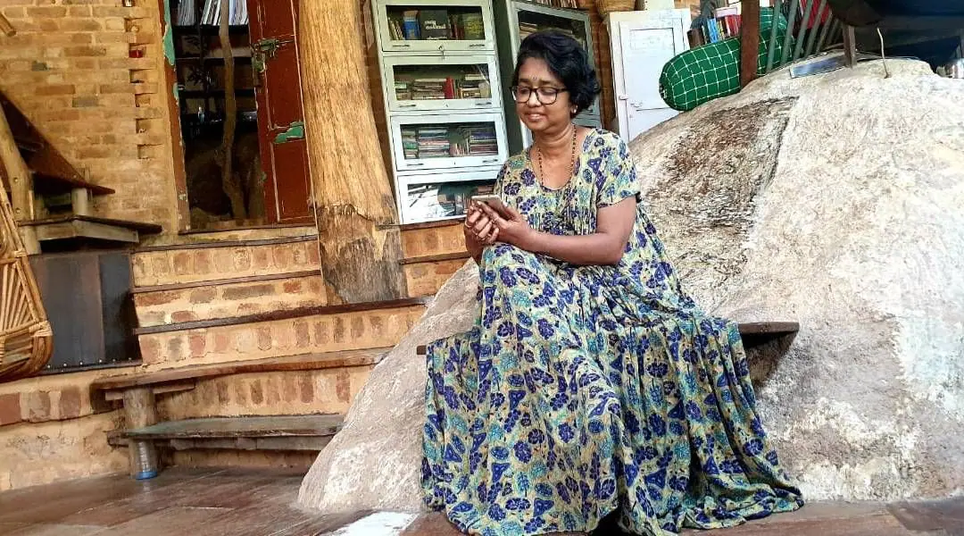 malayalam writer echmukutty sits on a rock chair in her eco friendly house in kerala