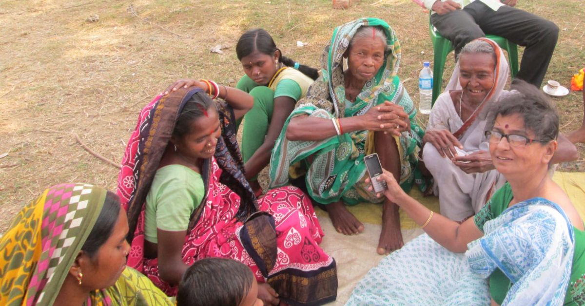 kolkata educator chandra mukhopadhyay stands next to rural women folk singers