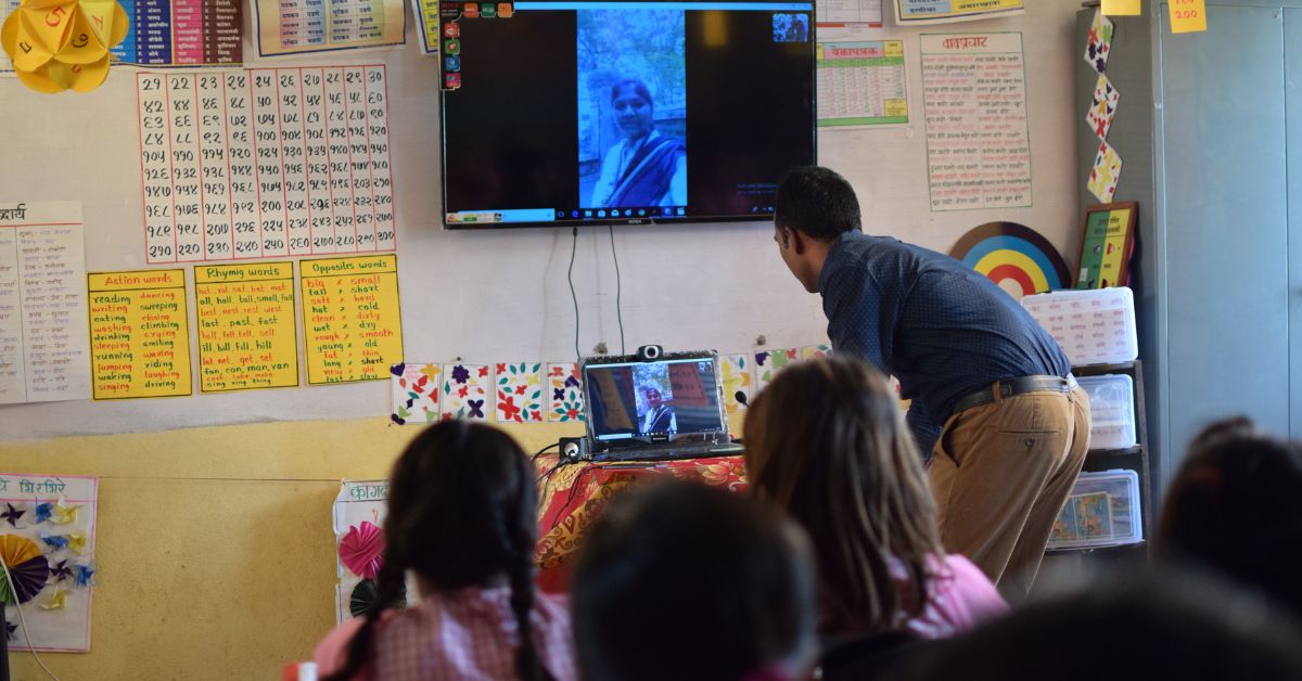 teacher ranjitsinh showing his students a laptop in class