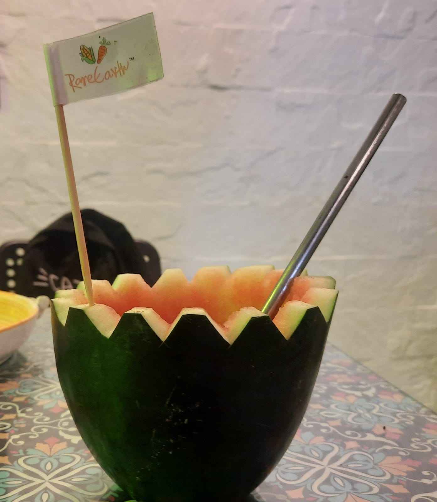 a vegan drink being surved in a hollow melon at vegan cafe in khar mumbai