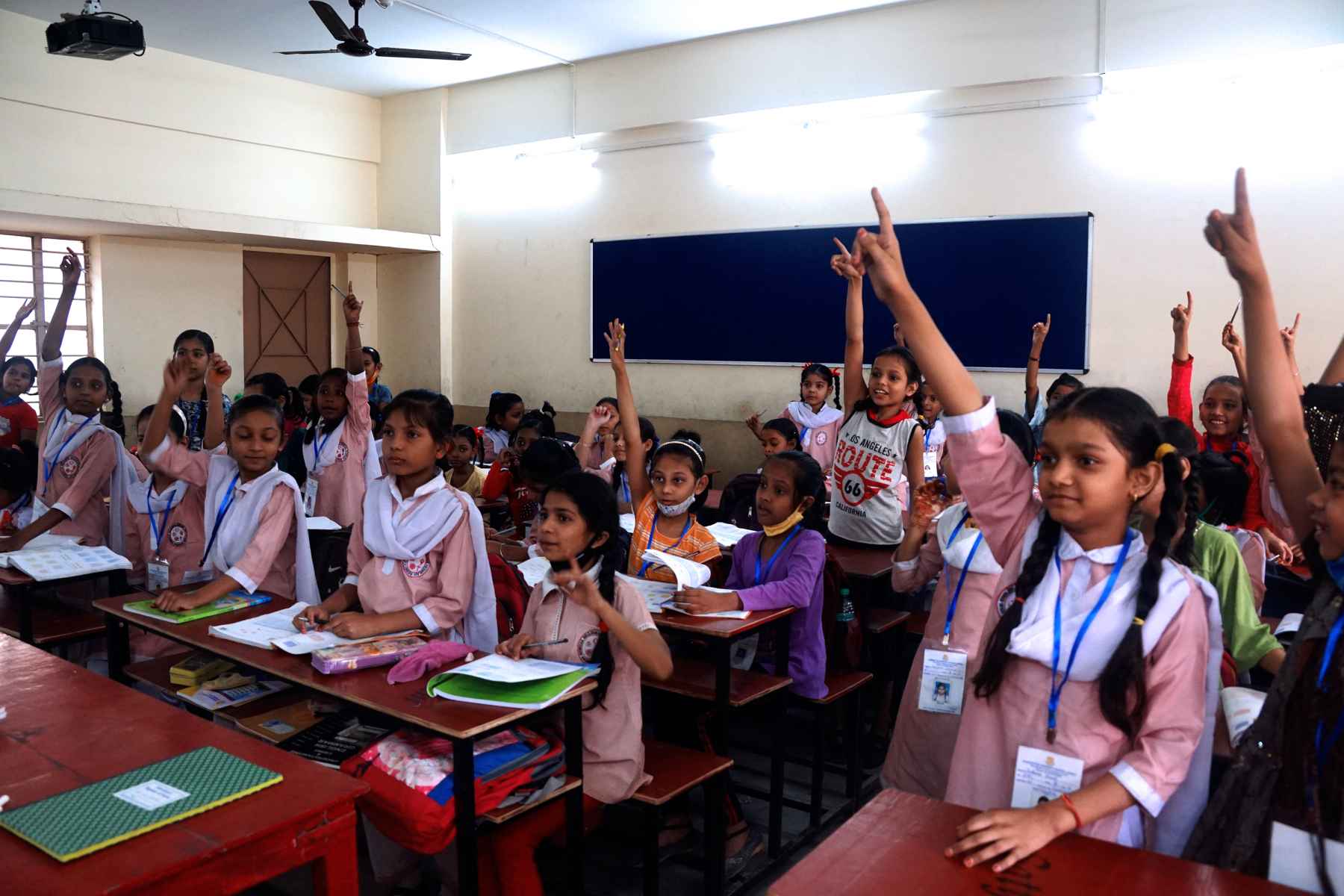 School children raise their hands at Samaritan Mission School 