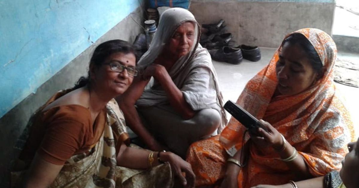 kolkata educator chandra mukhopadhyay stands next to rural women folk singers