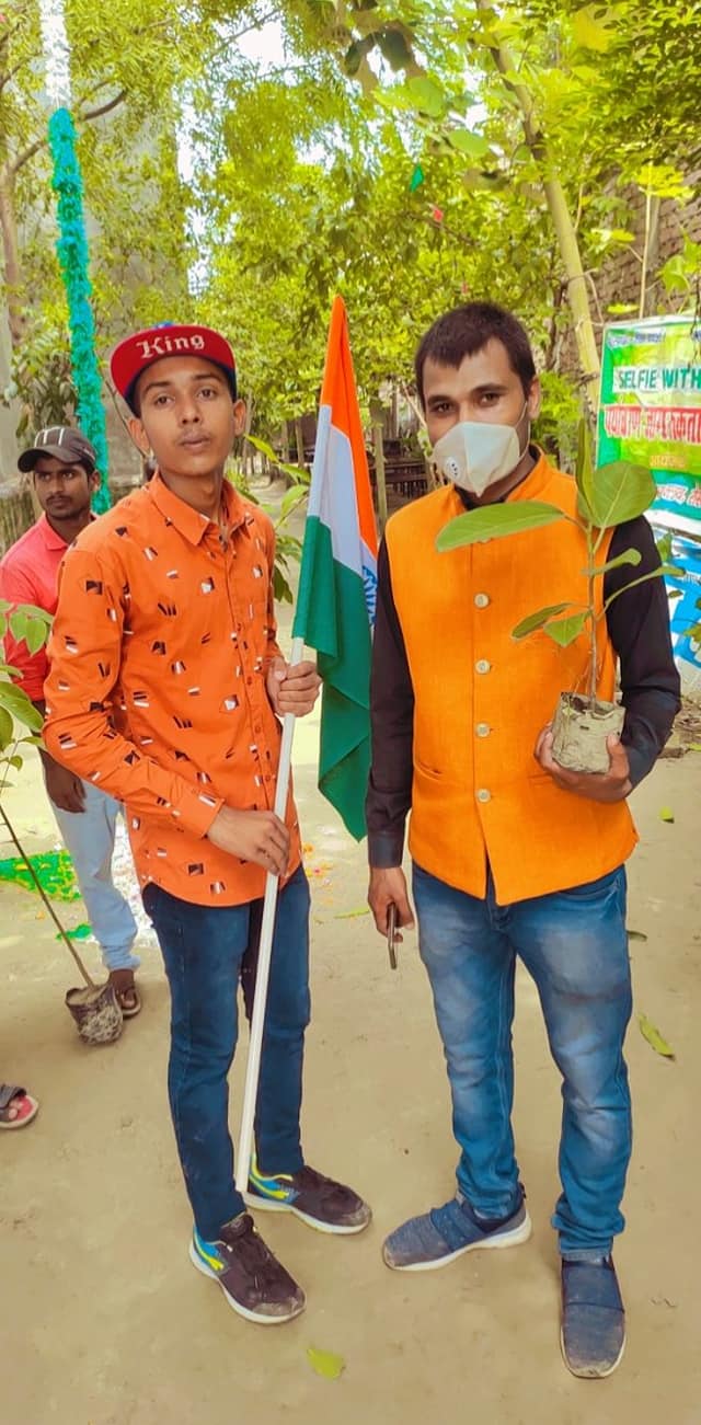 Rajesh Kumar Suman planting a sapling with a student