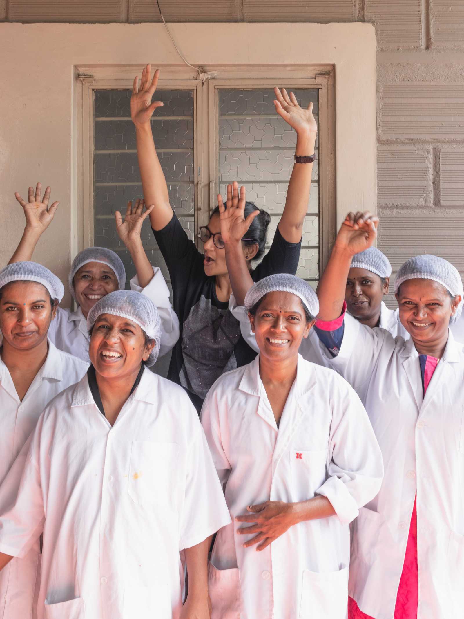 women employees of swa artisanal syrup wear hadcaps and pose with founder vaishali mehta 