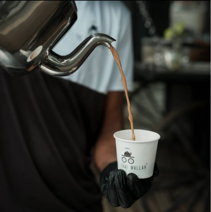 tea being poured into a paper cup with the label chai wallah 