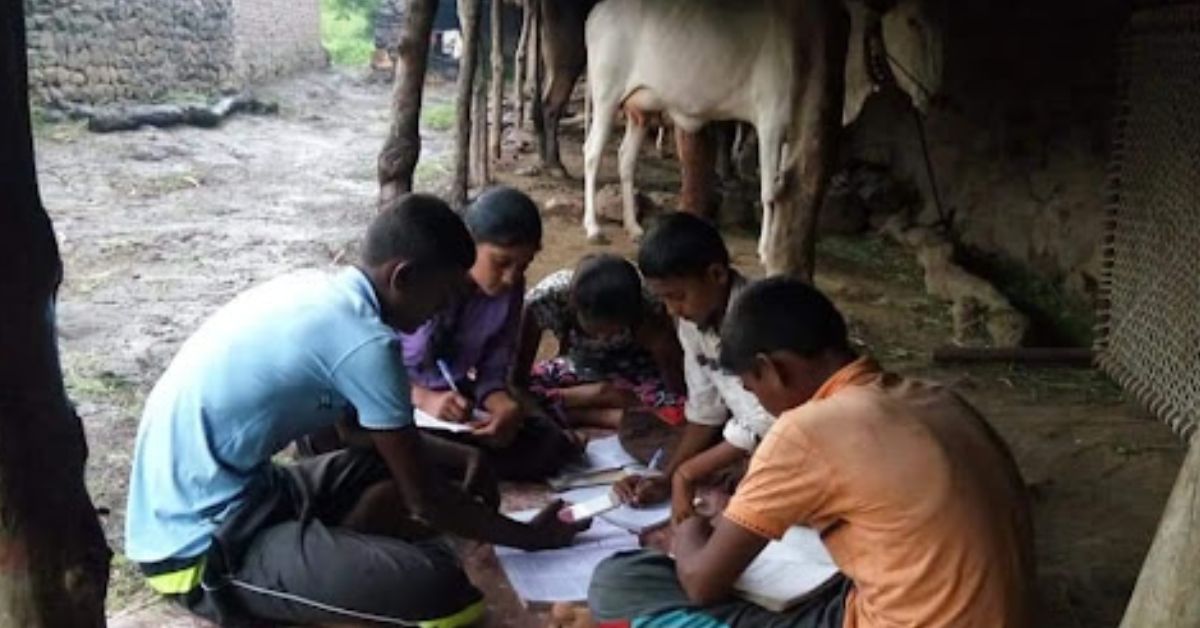 children gather near a cowshed to use an online app to study 