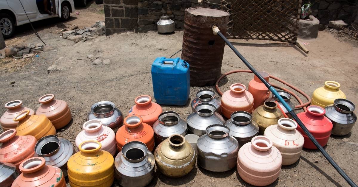 Jars of water waiting to be filled from a small piped tank in Marathwada 