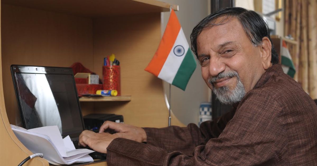 indian rti activist and former central information commissioner shailesh gandhi works on his computer next to an indian flag