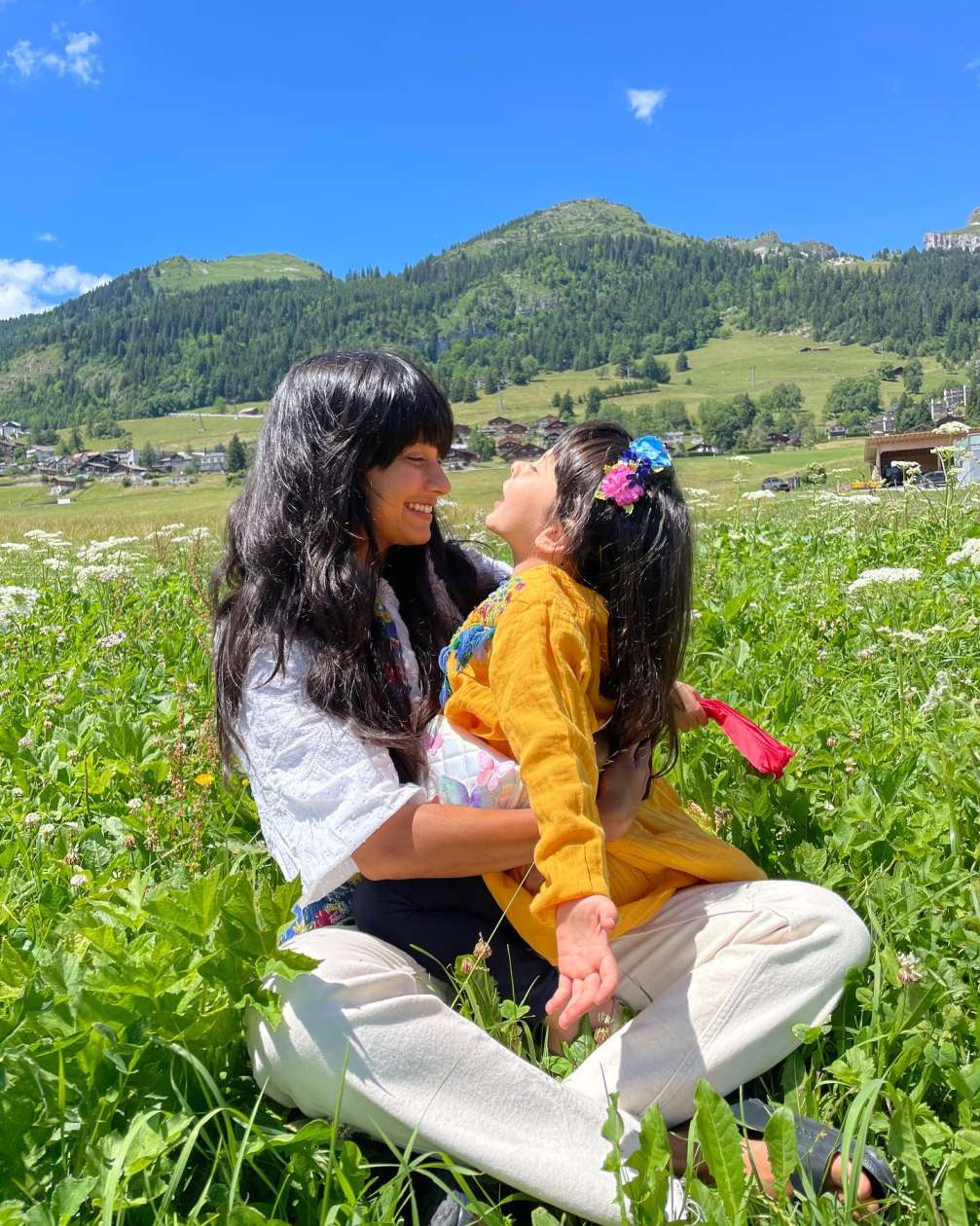 A green meadow in which Chef Chinu Vaze is seen with her young daughter. 