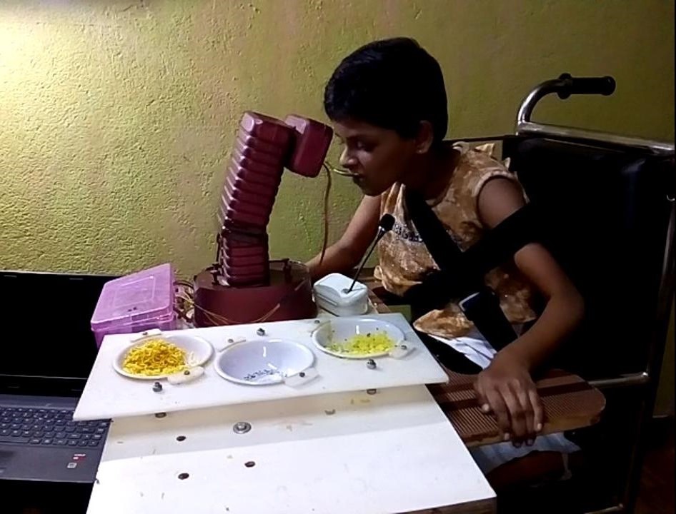 Bipin's daughter eating with the help of the robot he built