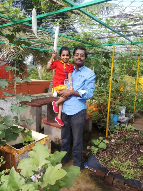 Thayumanavan dengan putrinya di teras rumahnya di Tamil Nadu