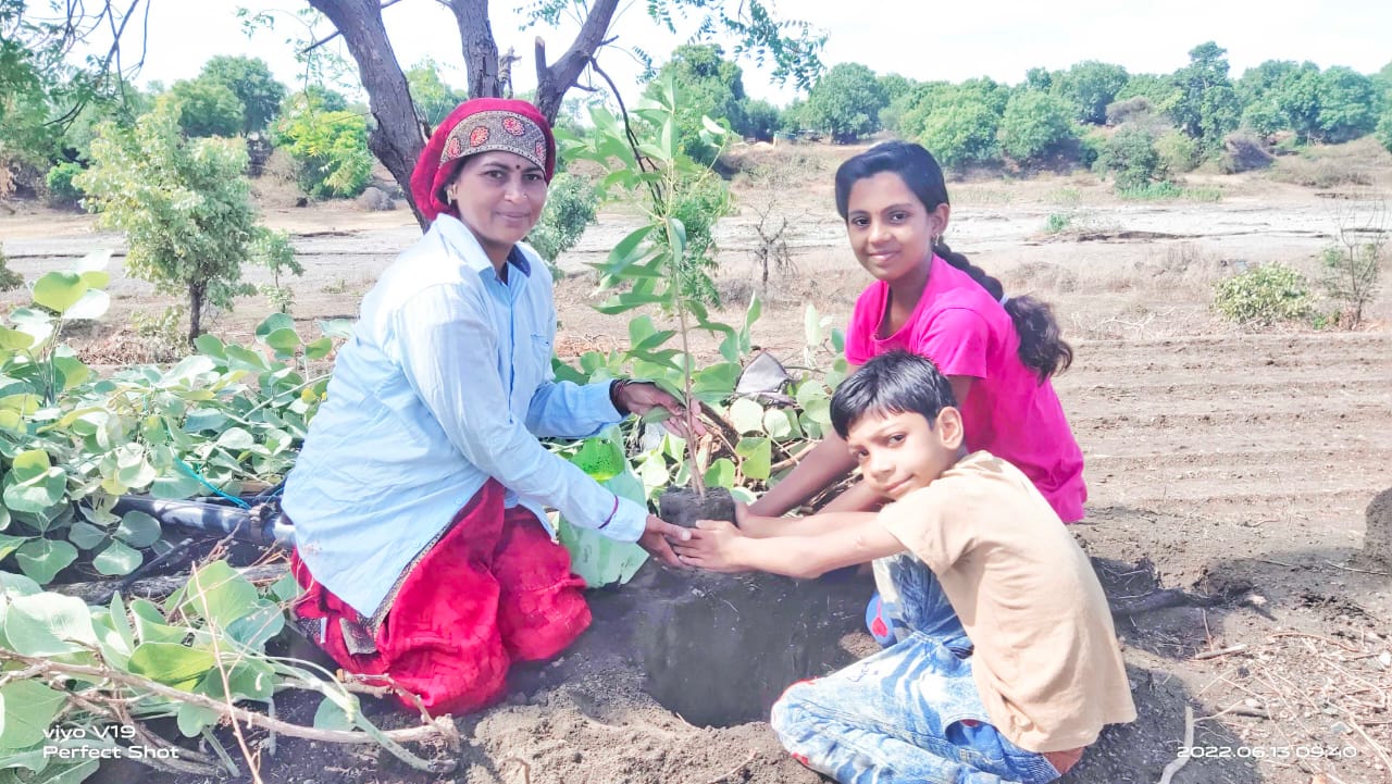 Savita Dakle and her children in the field. 