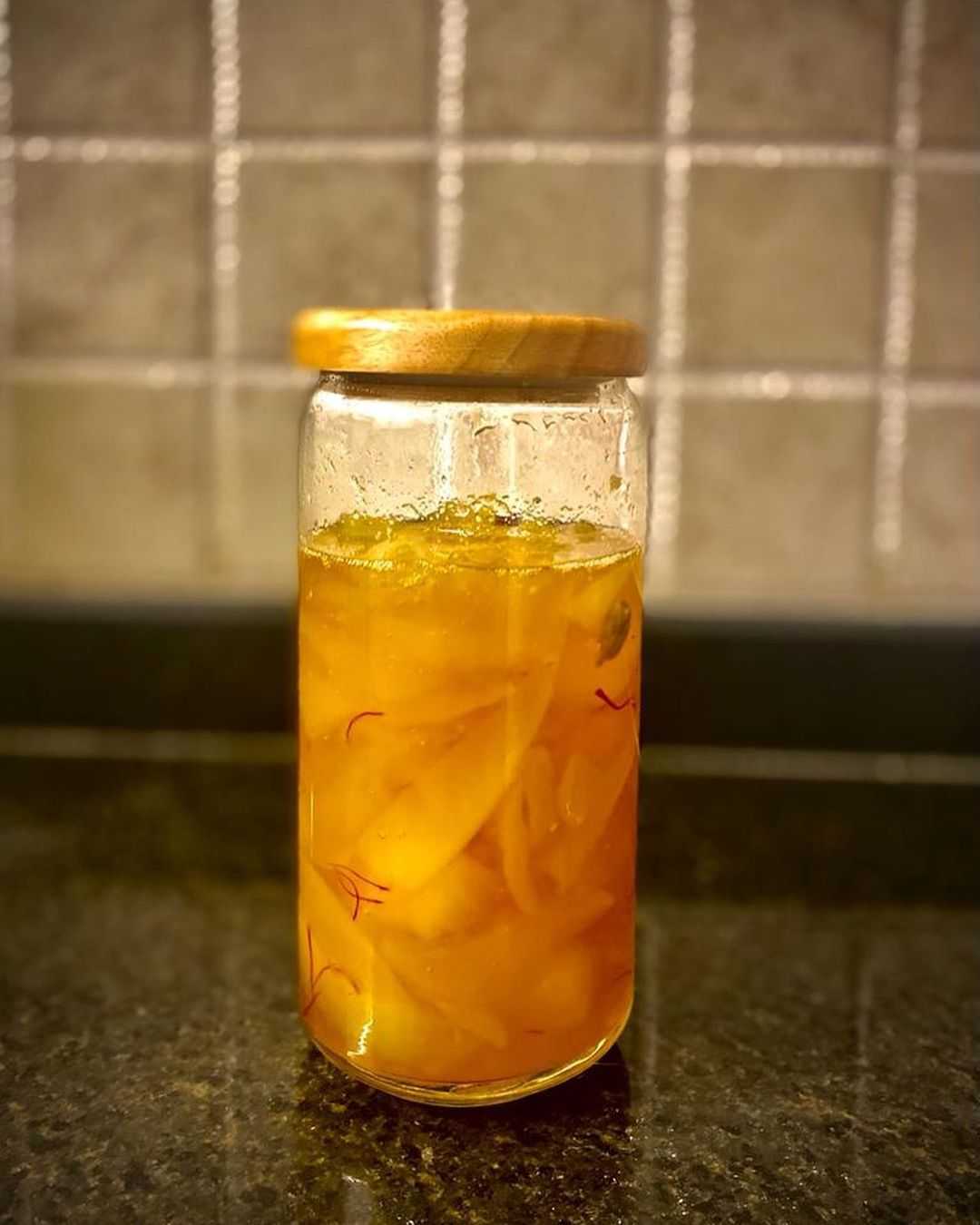 raw mango soaked in sugar syrup to prepare aam murabba