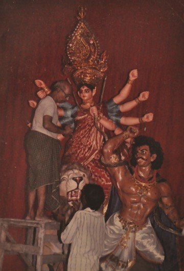 artists add finishing touches to a durga idol