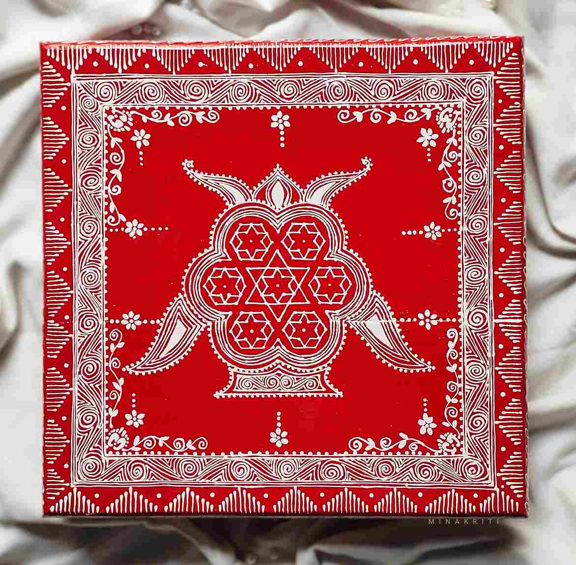 Aipan art that is made with rice flour on a red background as a traditional art form in Uttarakhand