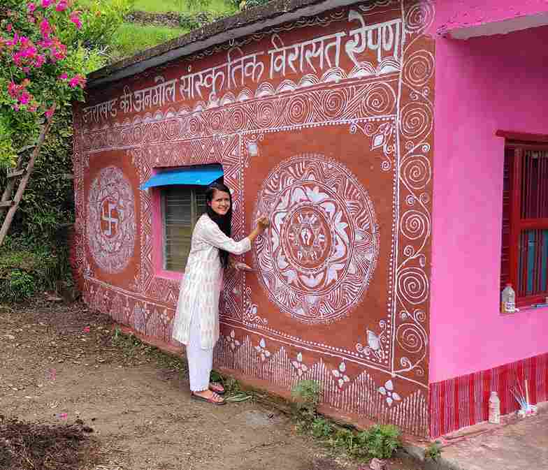 Minakshi Khati engaged in aipan art on the walls of the home