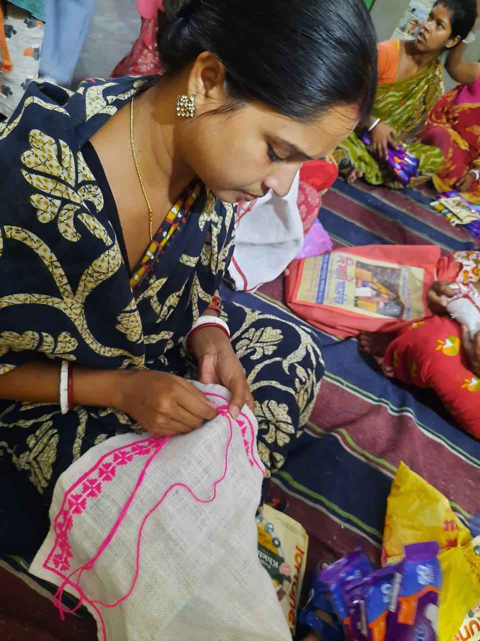 One of the women stitching clothes for children at Khudey