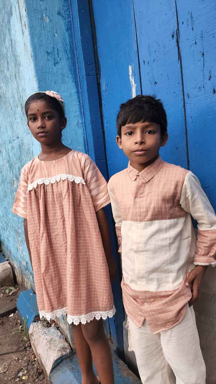 Anak-anak memodelkan pakaian ramah lingkungan berkelanjutan yang dijahit oleh ibu mereka di Khudey