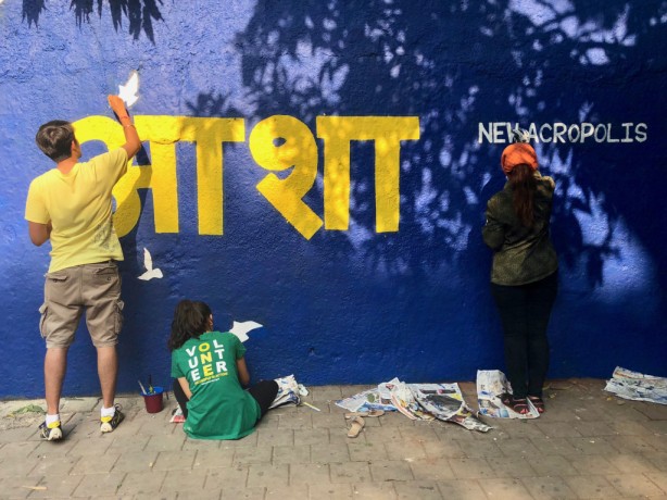 members and volunteer at new acropolis school of philosophy paint a wall 
