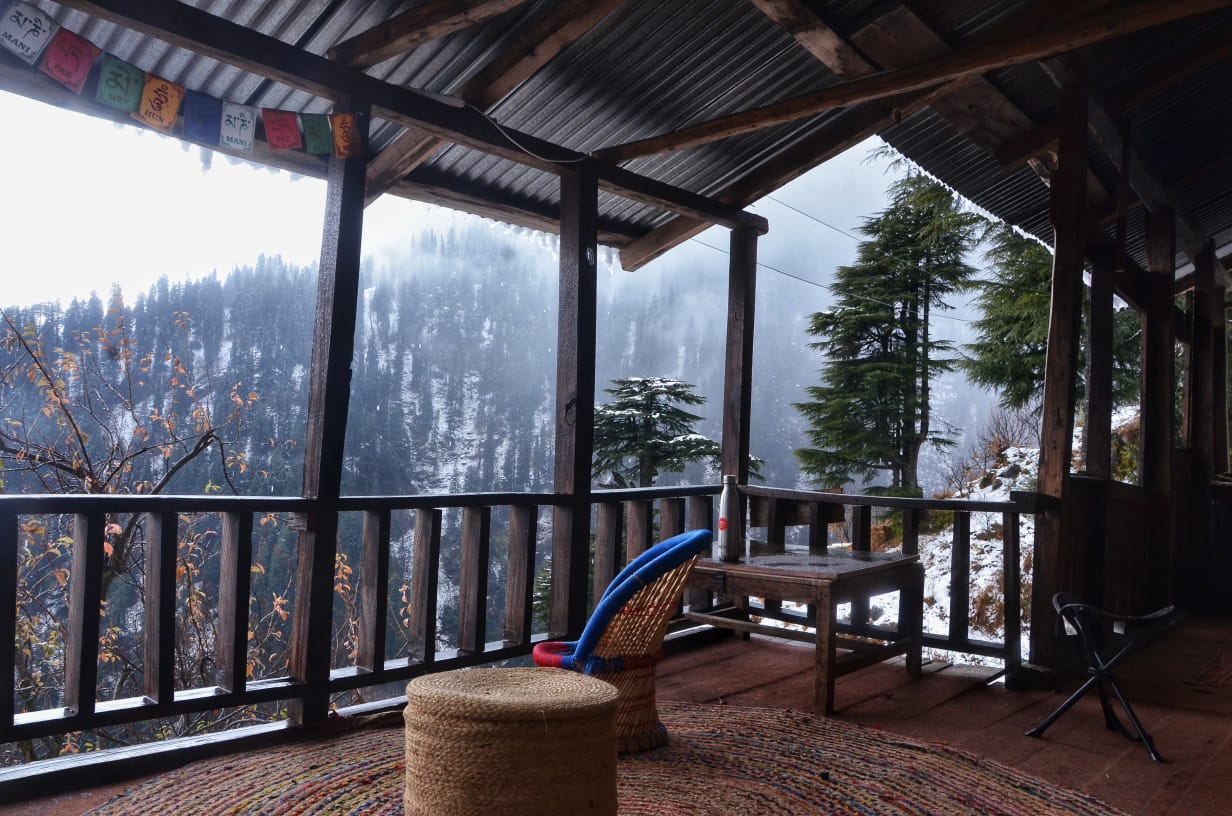 balkon dengan pemandangan pegunungan di hutan gubuk homestay ramah lingkungan di manali 