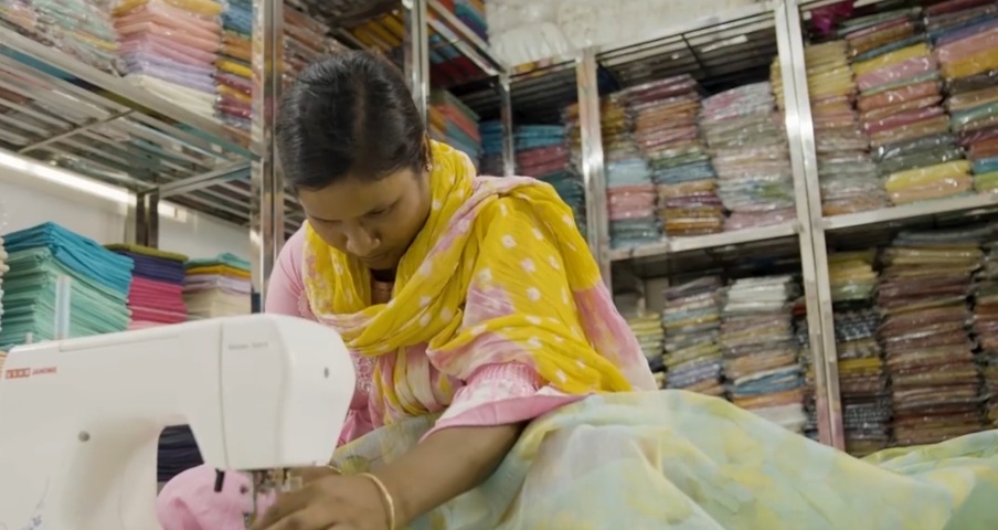 a weaver at kota doria silk stitches fabric at a store 