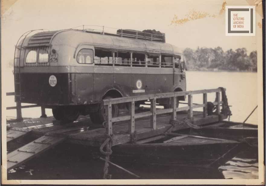 A bus suspended across two boats as a way of travelling.