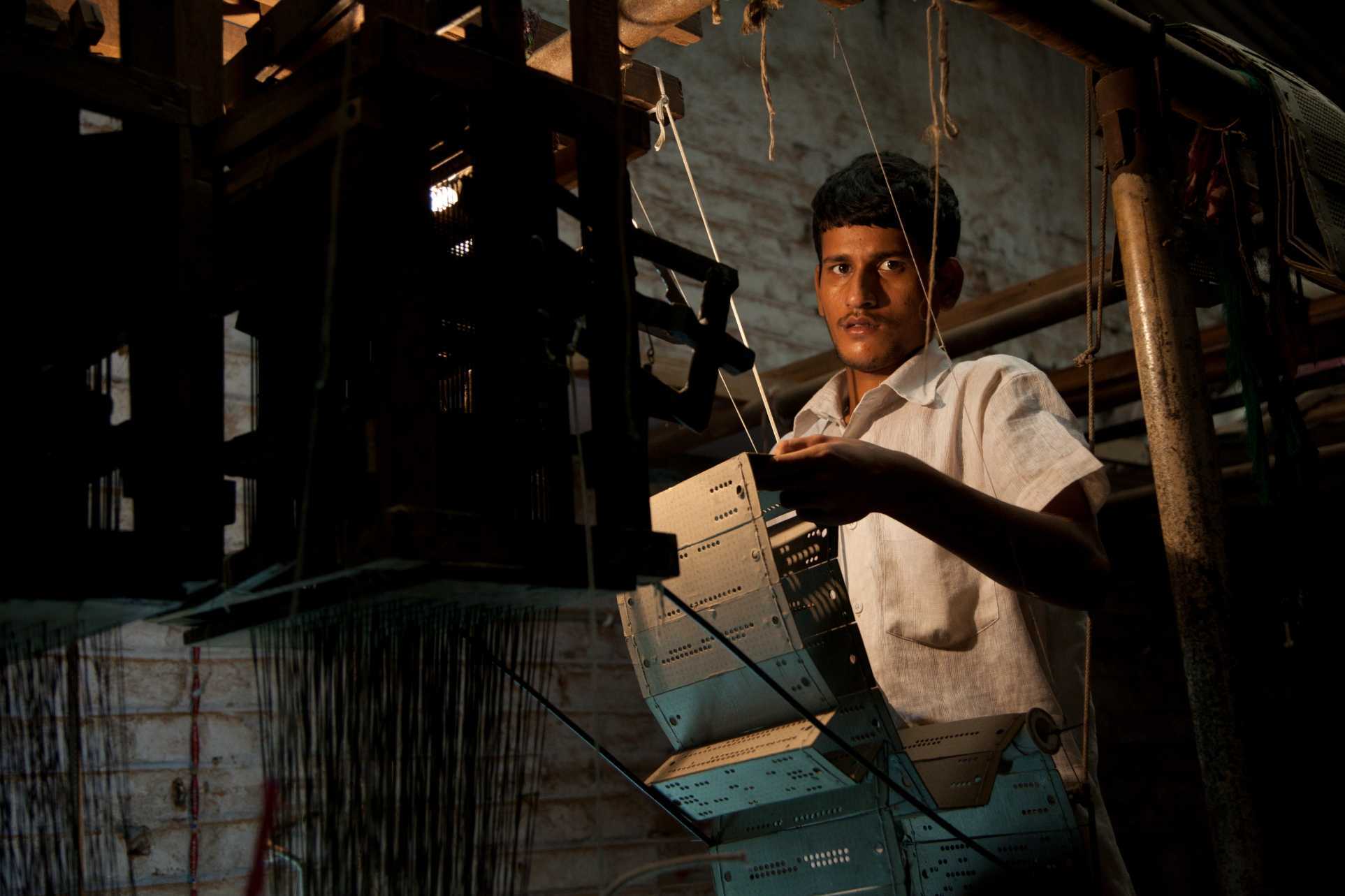 Para perajin yang bekerja di Royal Brocades menenun di Gujarat dengan teknik jacquard.