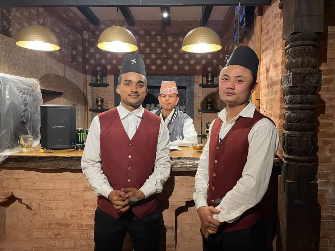 Workers mostly from West Bengal’s Siliguri and Darjeeling wearing dhaka topi (hat) attend to diners.