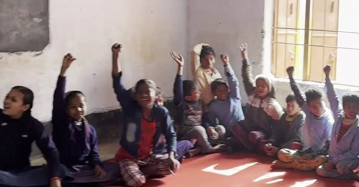 Smiling children raise their hands on being asked if they watch cartoons