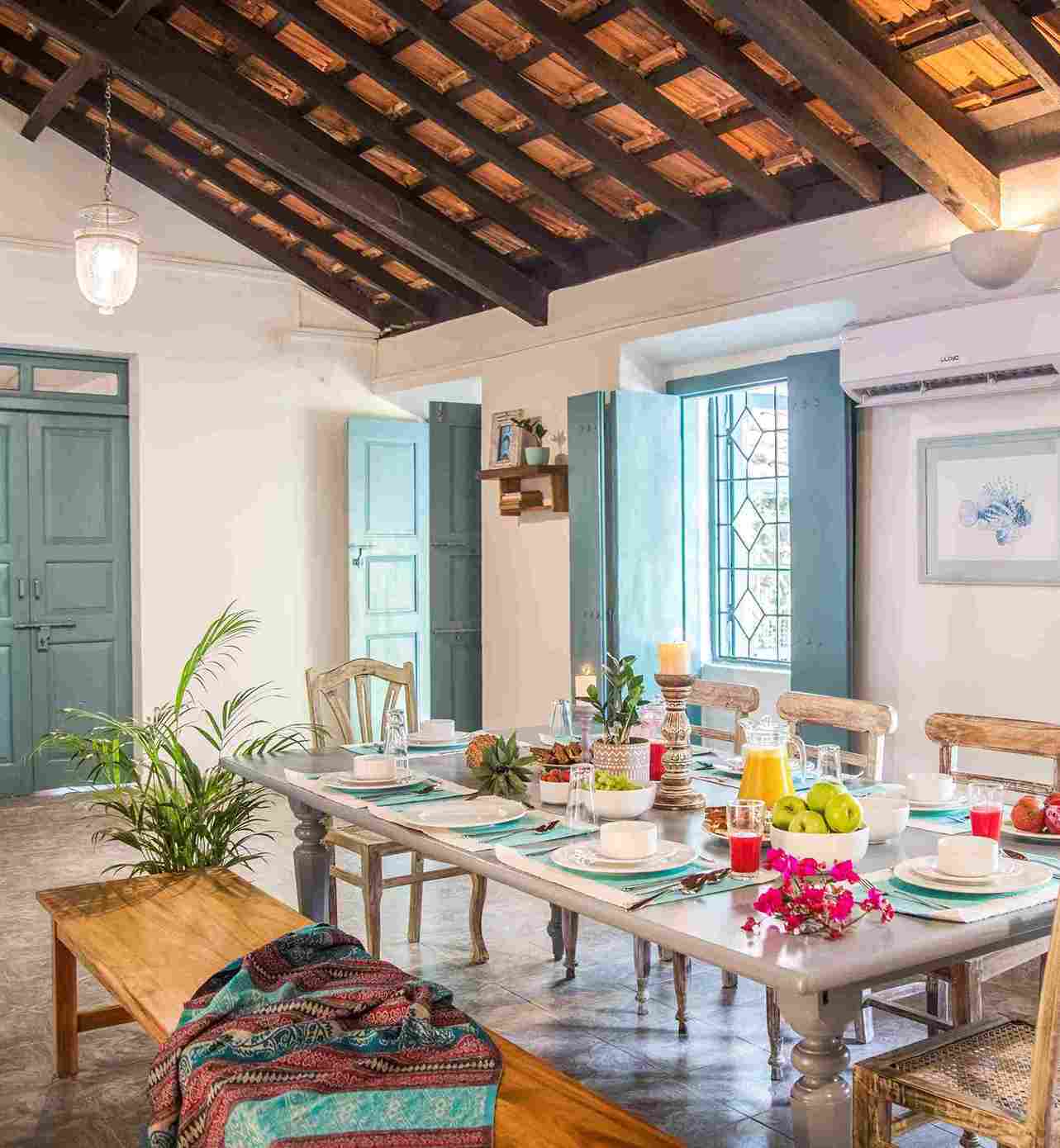 Ruang makan di Villa Saudade memiliki kayu alami sebagai komponen utama dengan lampu dan dekorasi yang bersumber dari pasar lokal,