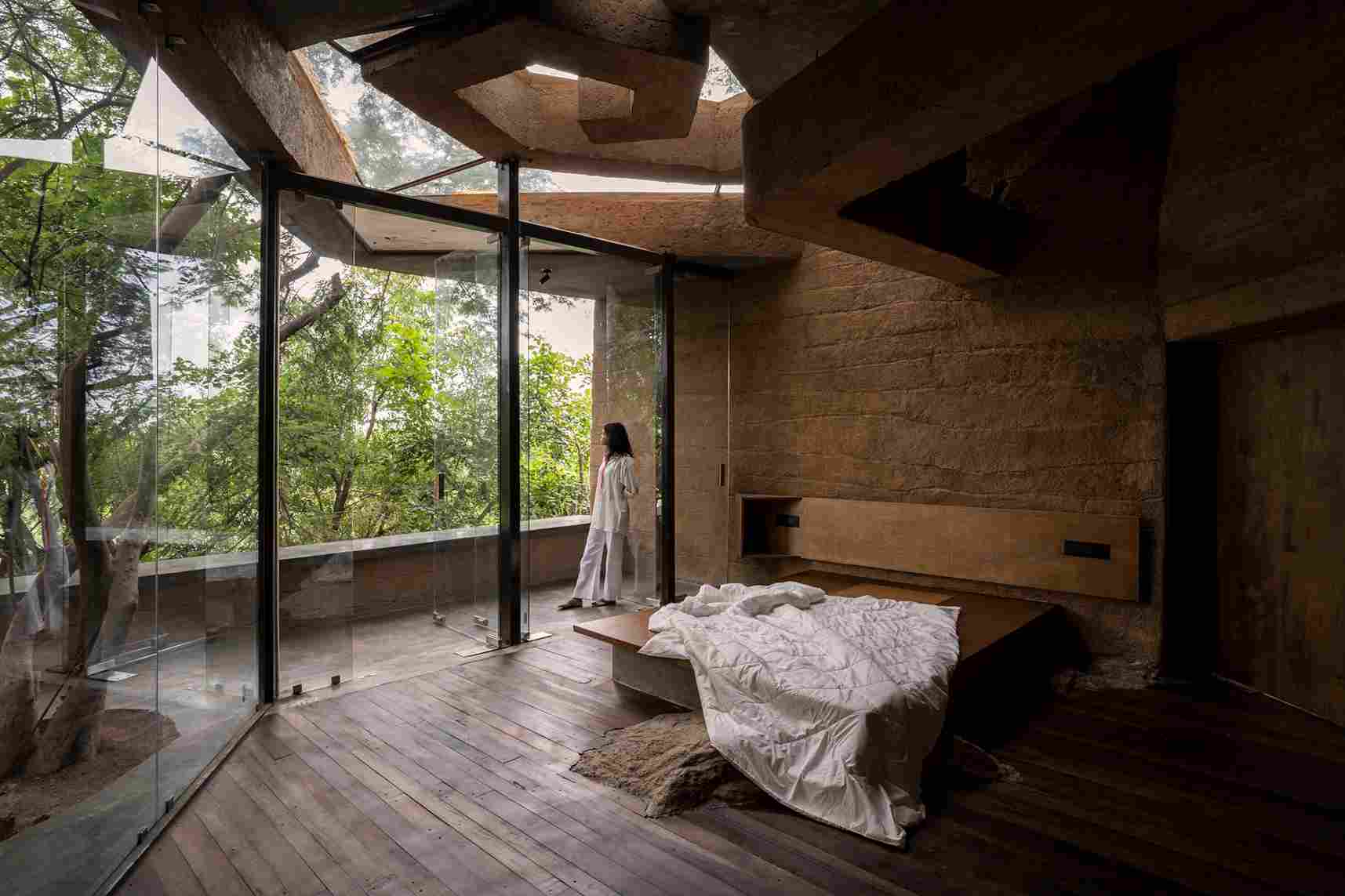 Kamar tidur di Chuzhi memiliki lantai yang terbuat dari kayu reklamasi dan dinding lumpur