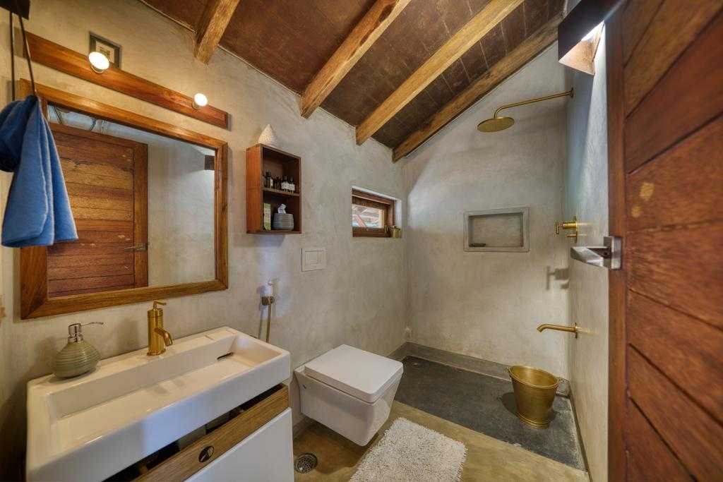 Kamar mandi rumah ramah lingkungan terbuat dari batu laterit dan kayu daur ulang