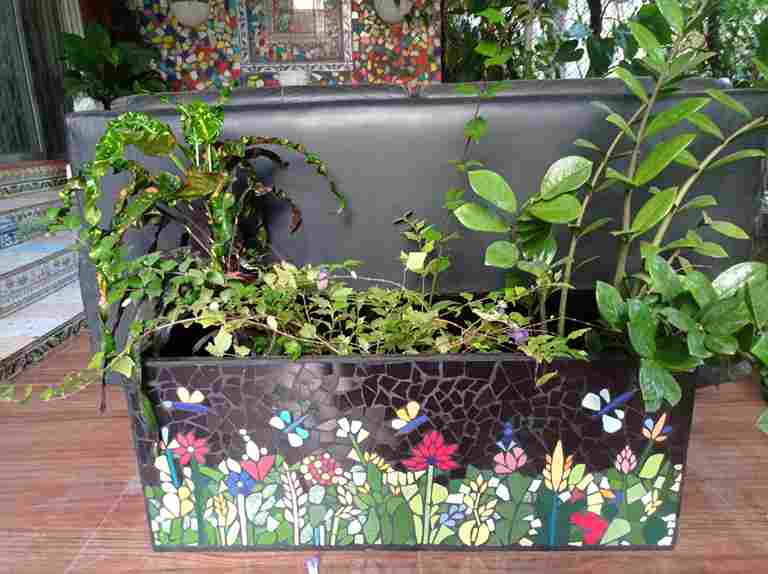 A large planter made with mosaic art.