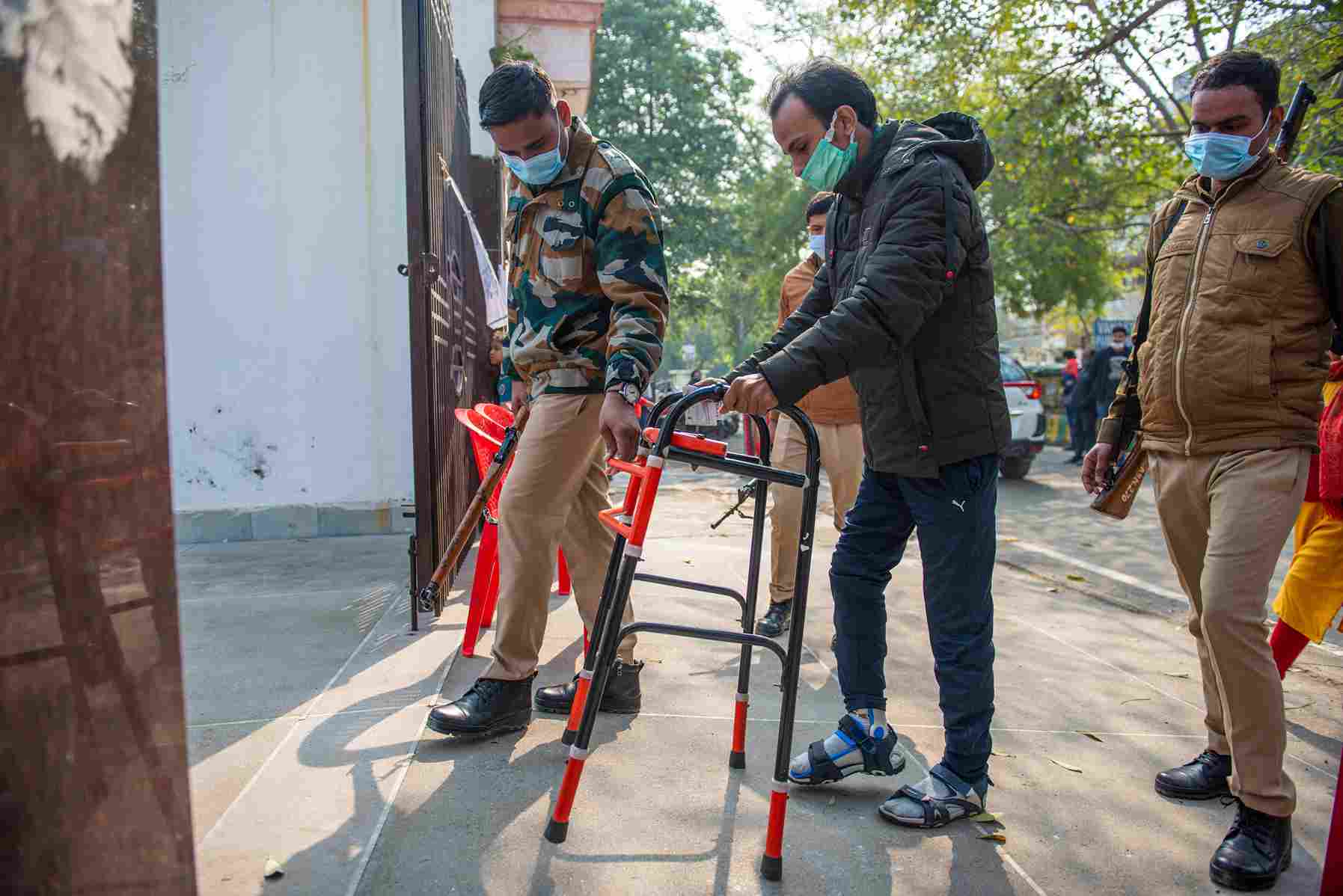 A disabled man being helped by a police officer into a polling booth in Ghaziabad, Uttar Pradesh in March 2022.
