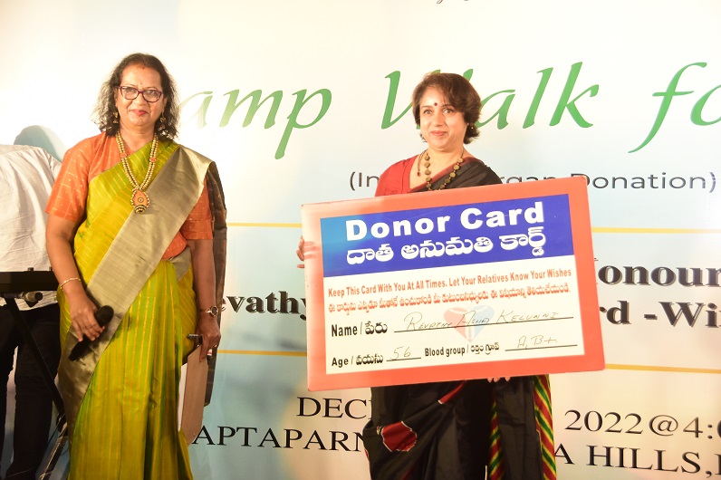 Actress Revathi holding up her donor card.