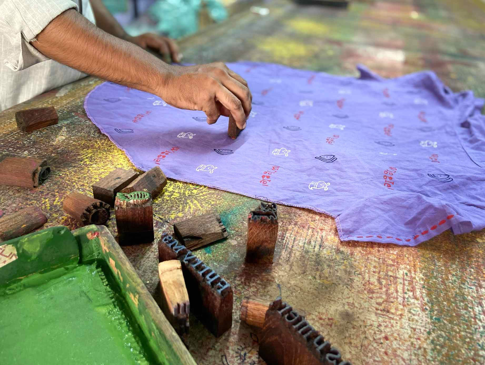 An artisan skillfully creates a product using traditional Indian textile techniques, showcasing intricate craftsmanship passed down through generations.