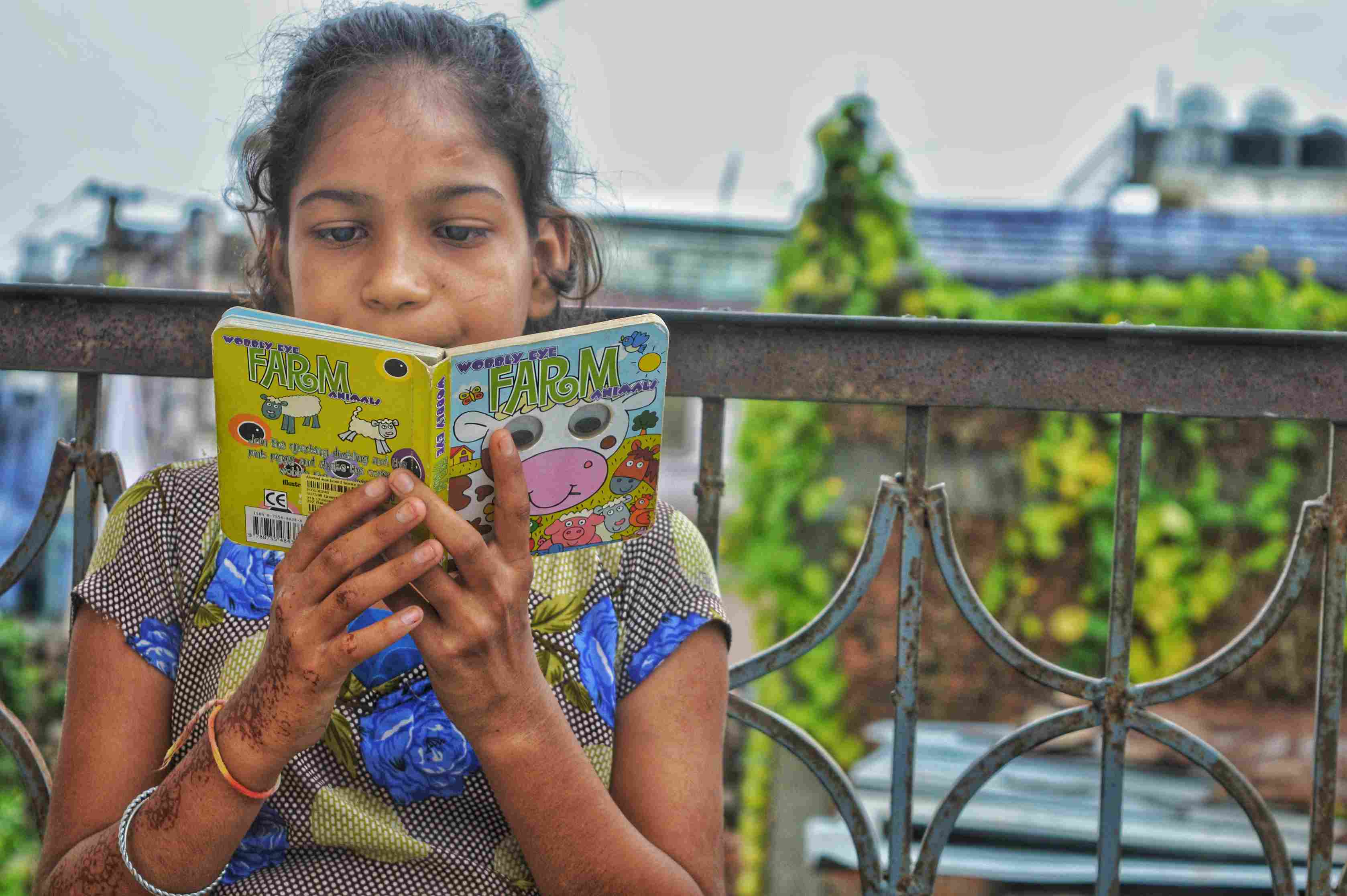 A 7-8 year old girl is given access to books in jaipur in an attempt to improve her reading grade level