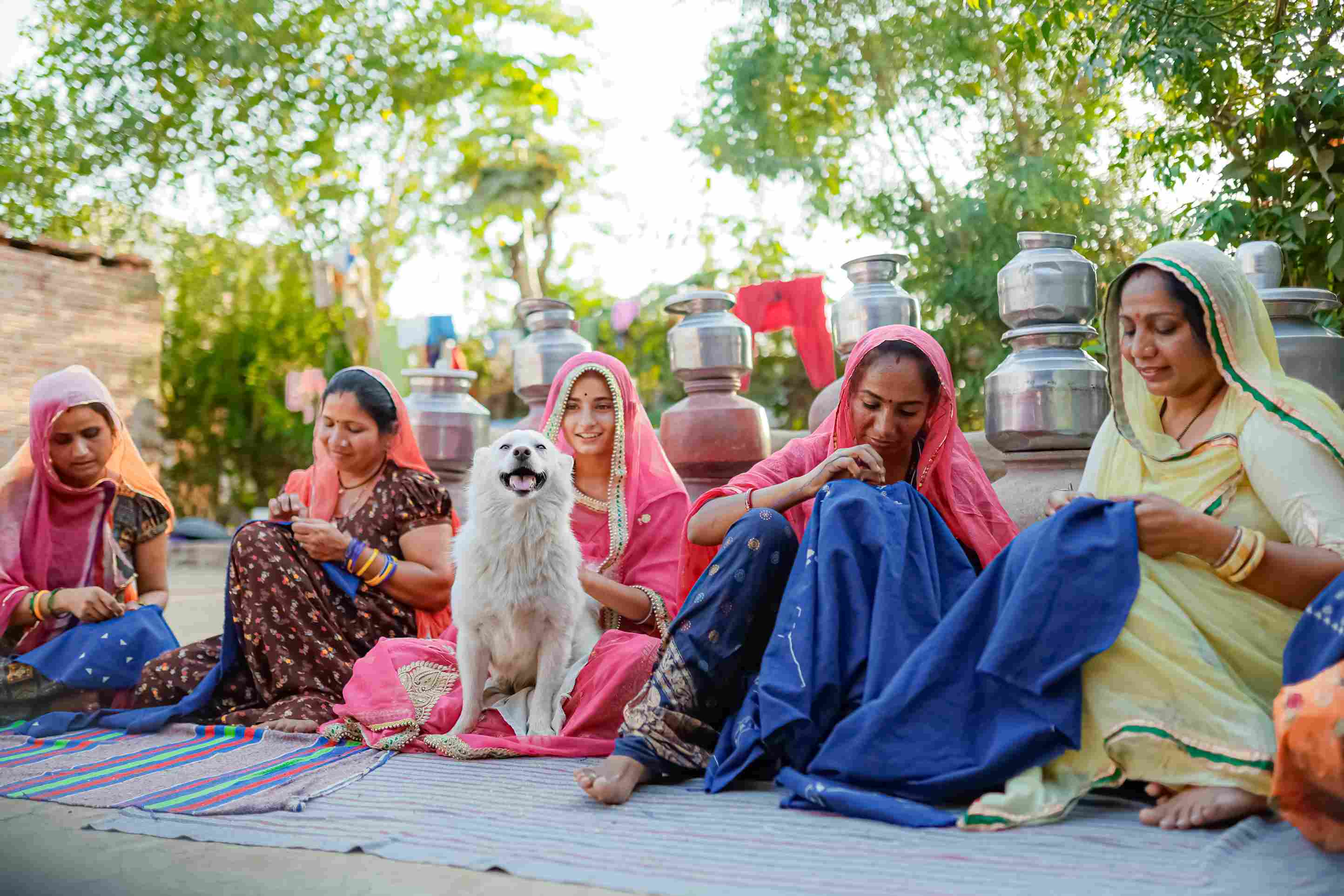 Indian artisans create eco-friendly pet products for IndieGood, while a happy dog sits nearby, showcasing the brand’s commitment to sustainability and craftsmanship.