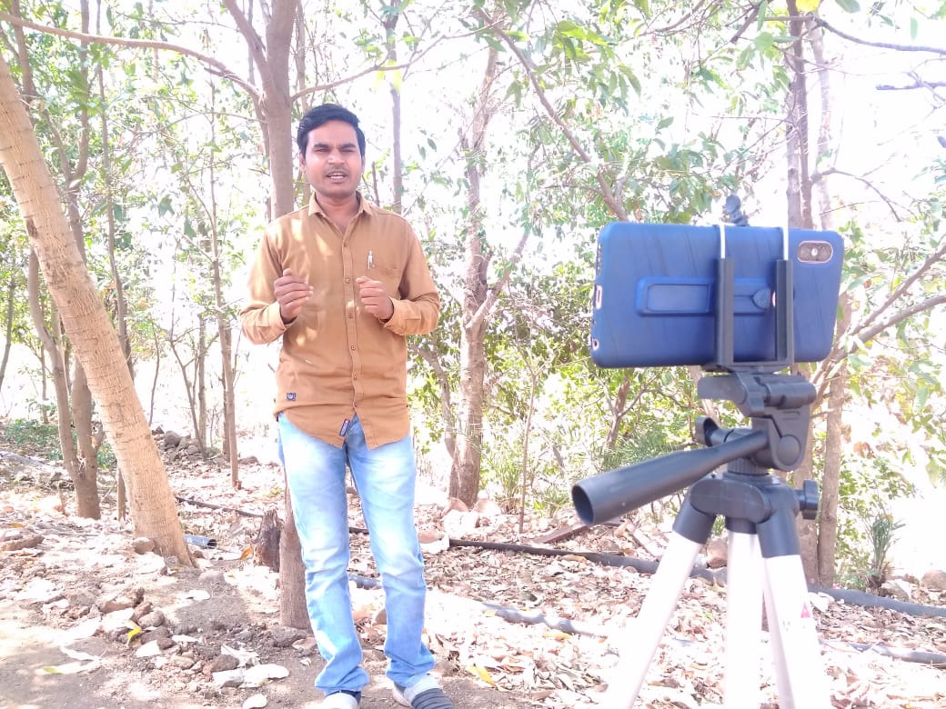 Rakesh Pawara recording a video on his phone which will be shared and screened for the tribal community to see.