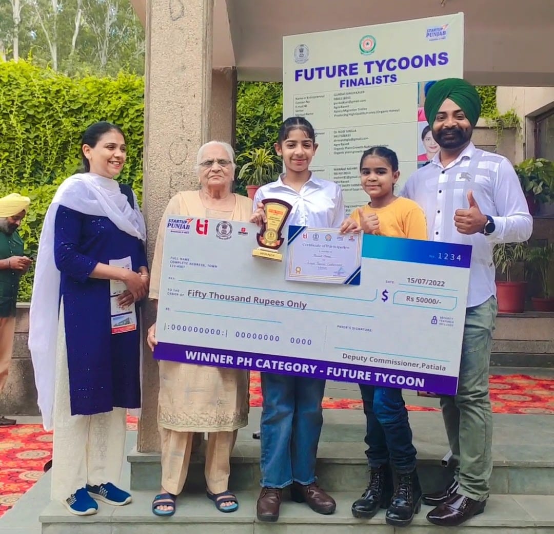 The Mehmi family posing proudly together after Mannat and Eknoor won the Future Tycoons Startup Challenge, with their award displayed prominently, celebrating their entrepreneurial success.