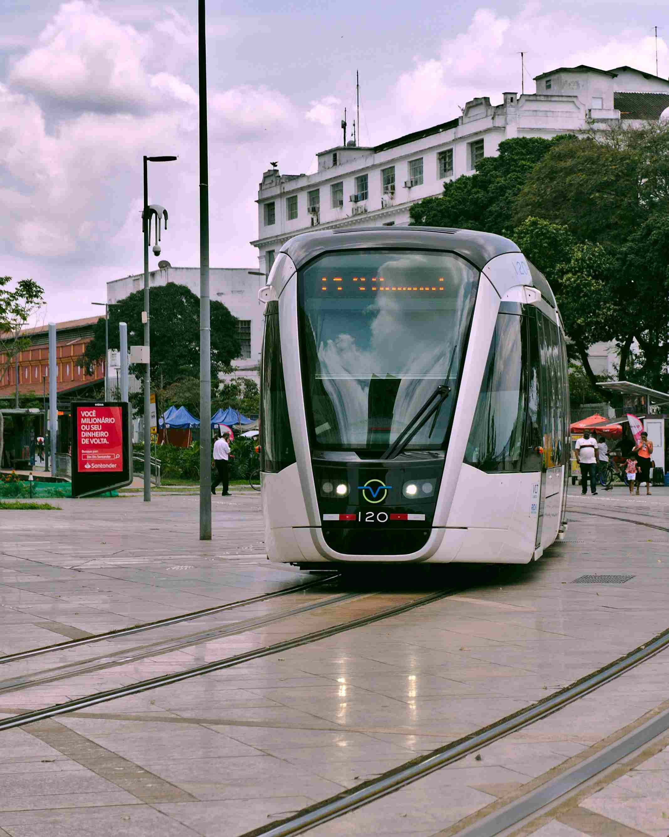 A tram in Barcelona traveling along a city street, part of the city's sustainable public transit network.