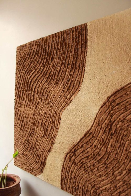  An artistic display of a brown and white painting on a wall, emphasising the use of all-natural materials in its design.