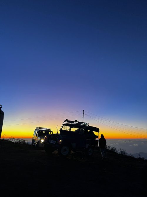 The sunset paints a silhouette of jeeps near Sandakphu