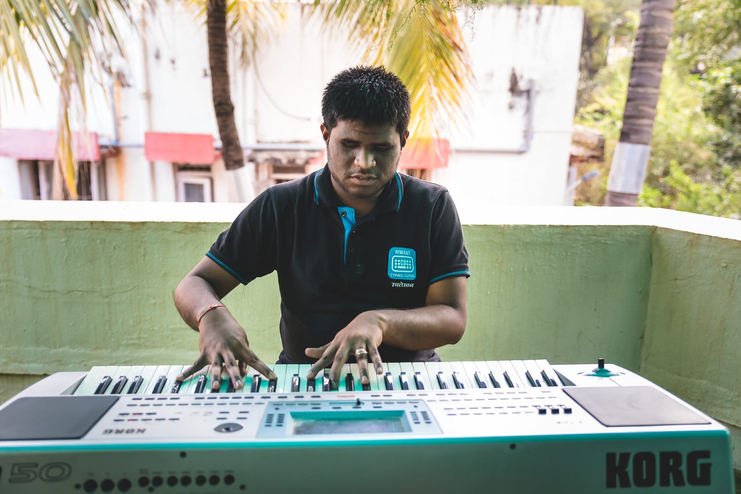 A Niwant fellow, who is visually impaired, playing the keyboard with focus and skill.