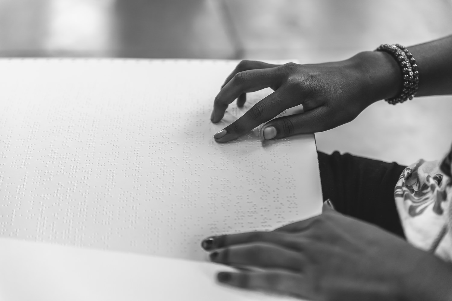 A girl reading a braille book, supported by Niwant's extensive braille library.