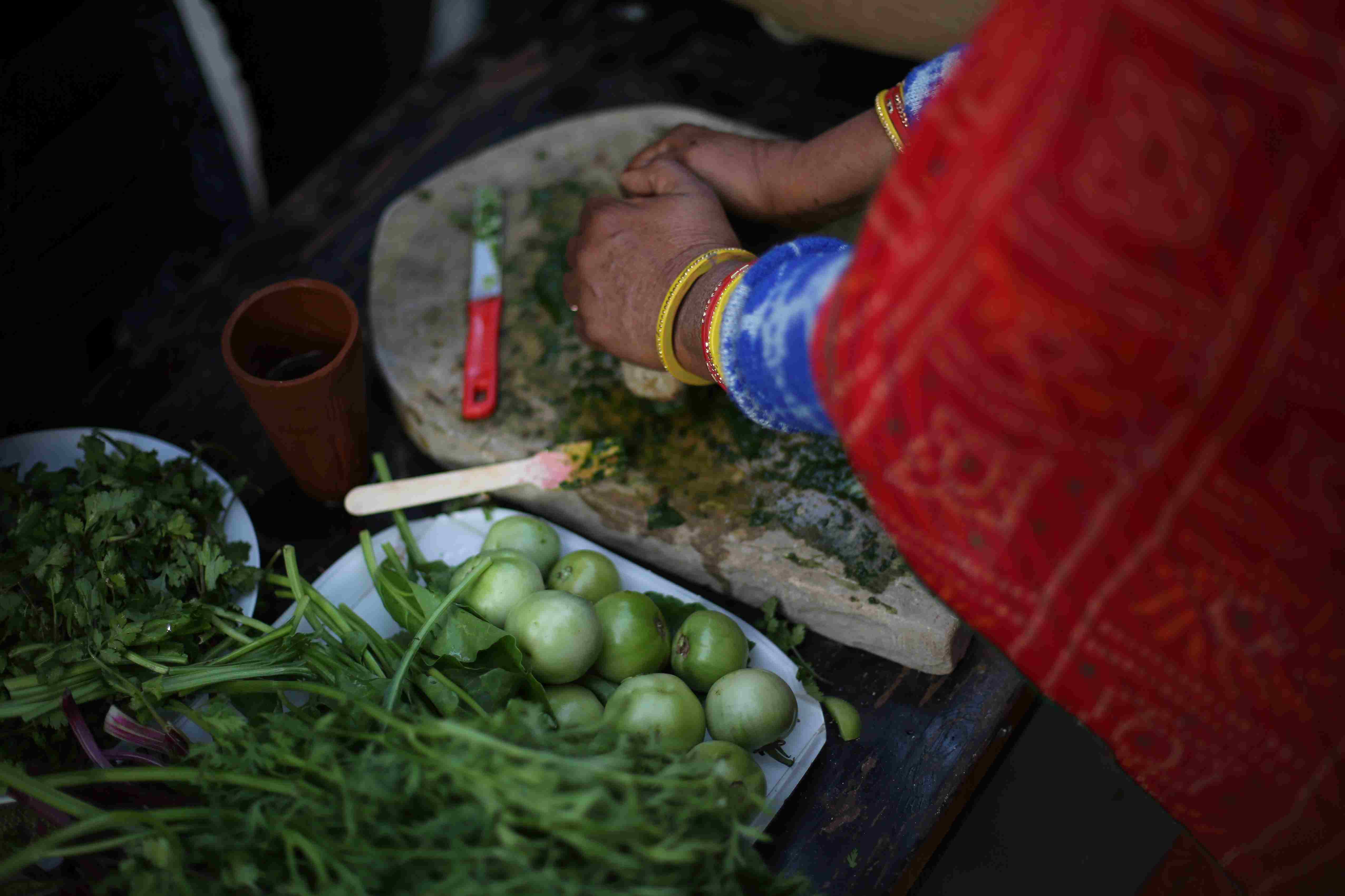 A Rajasthani woman using a 'silbatta', a traditional stone grinder to prepare her meal. 