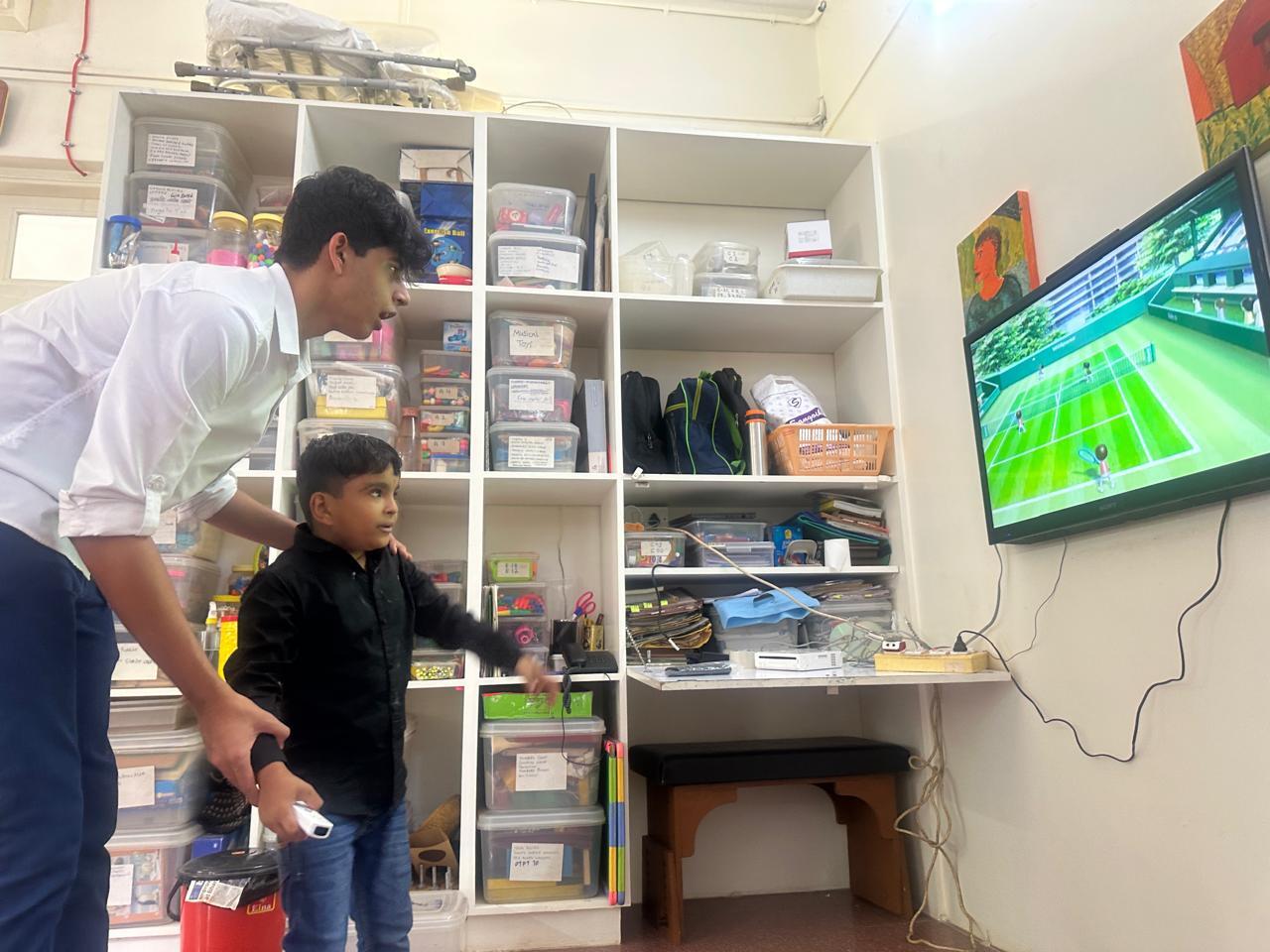 Siddhant supports the children as they play on the Nintendo Wii, helping them build confidence