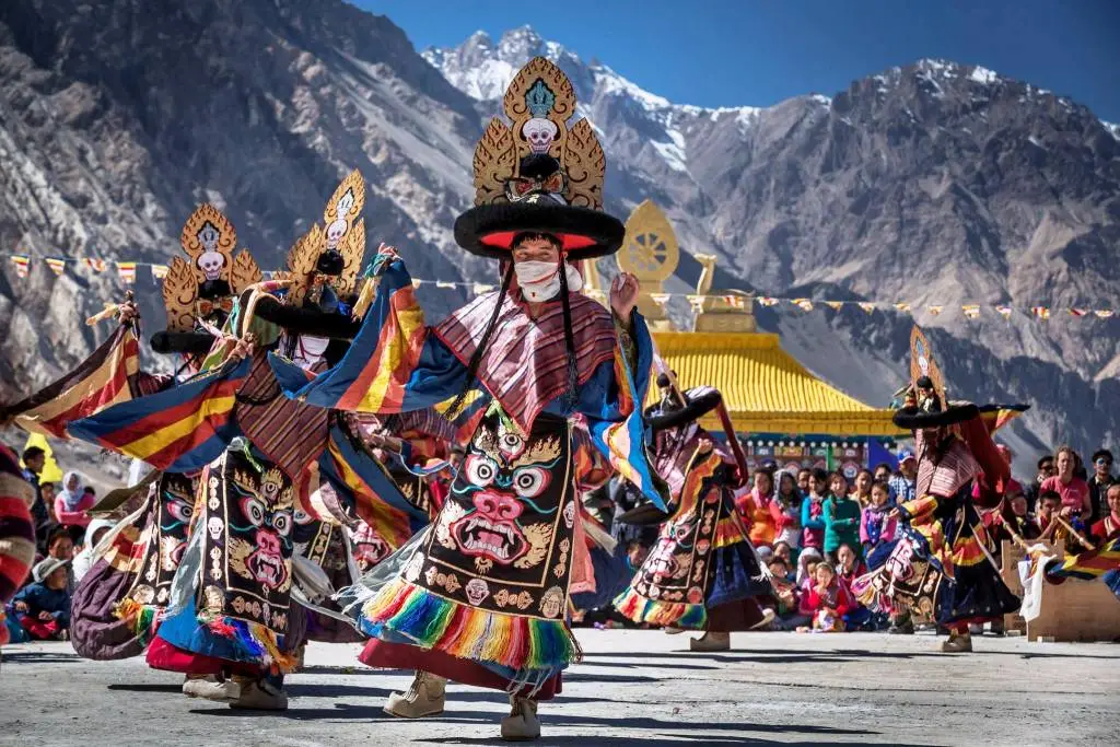 Ladakhi men dressed in traditional festive attire, dancing and celebrating the festival of Losar amidst the Himalayas 